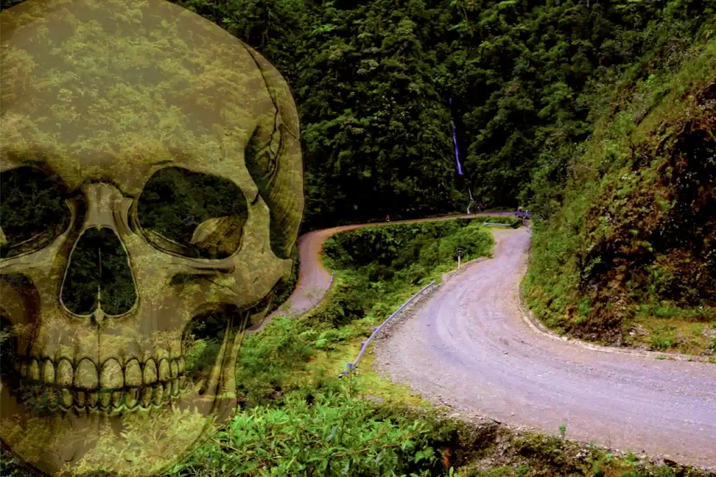 A winding mountain road cuts through lush green jungle on Bolivia’s Death Road, with a steep drop and no visible guardrails toward La Paz.