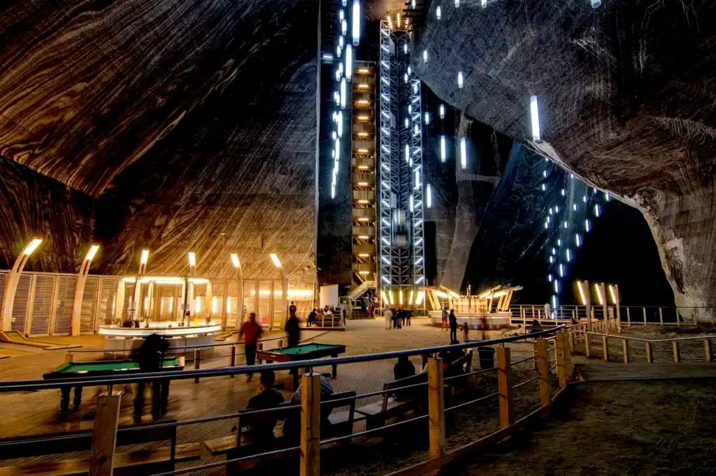 Inside Salina Turda’s underground chambers, a brightly lit Ferris wheel rises above wide walkways in the former salt mine, 120 metres below.