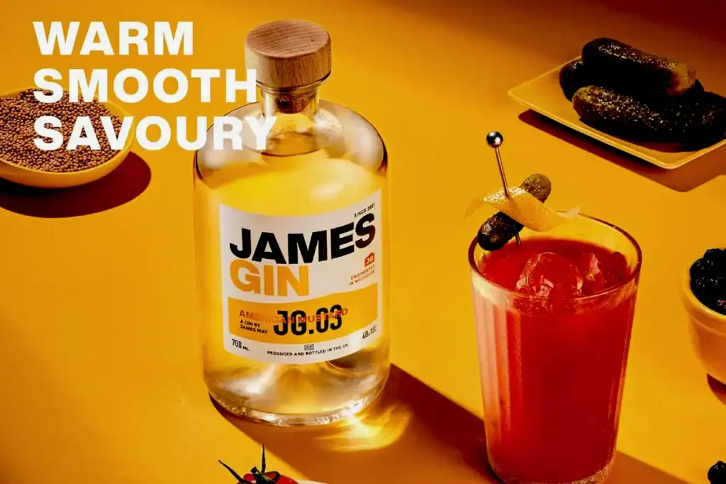 A James Gin bottle labeled American Mustard Gin next to a red cocktail, with “WARM SMOOTH SAVOURY” text on a warm yellow backdrop.