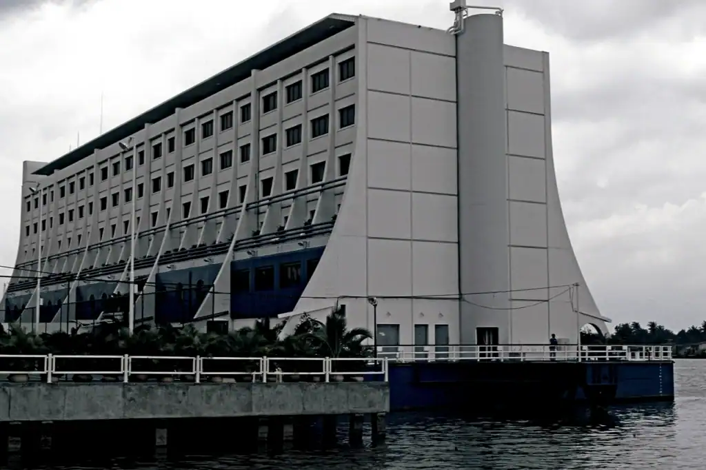 A grey multi-storey floating hotel ship with long rows of windows and a tall superstructure, tied alongside water in the North Korea story.